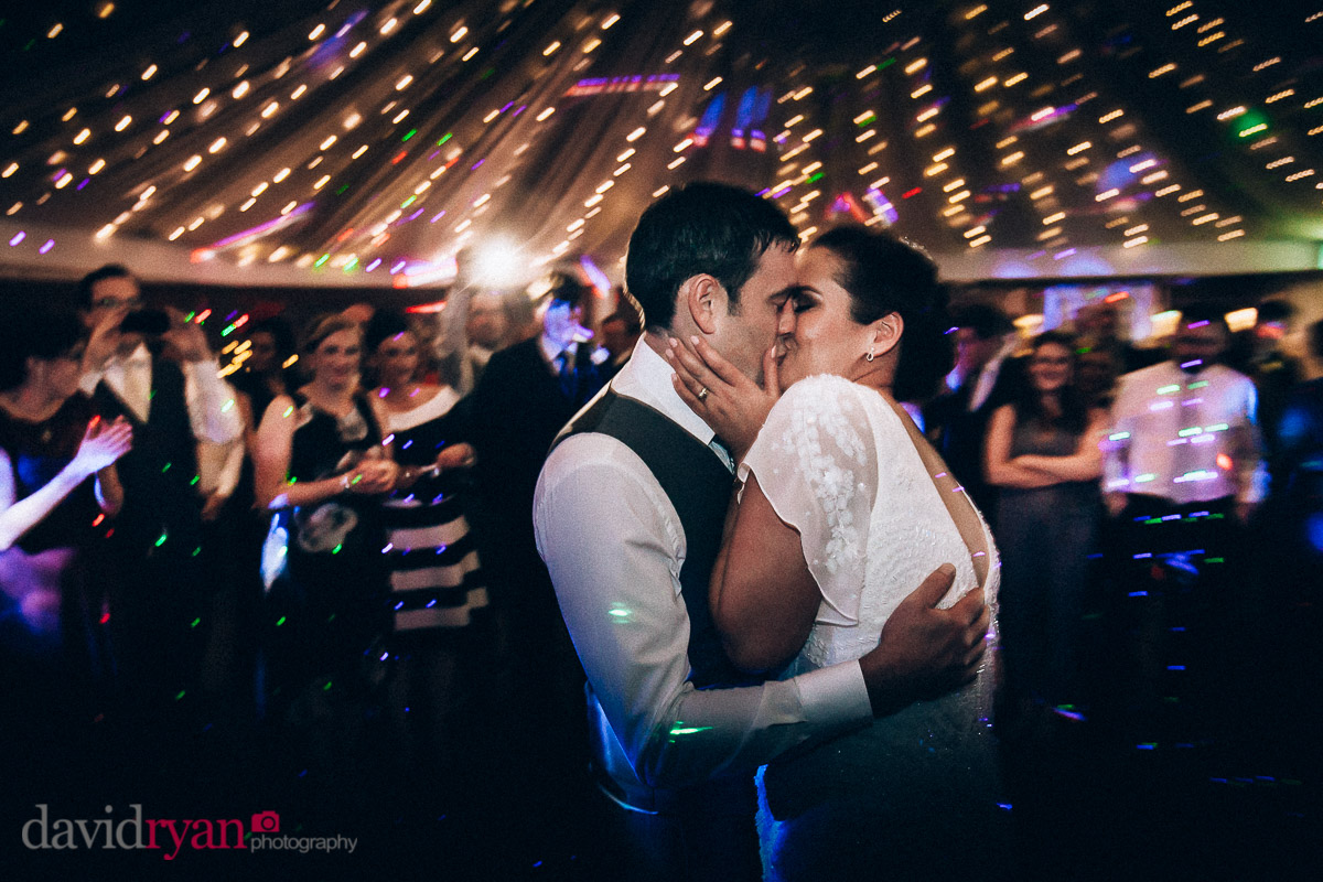 bride and groom kiss on dancefloor