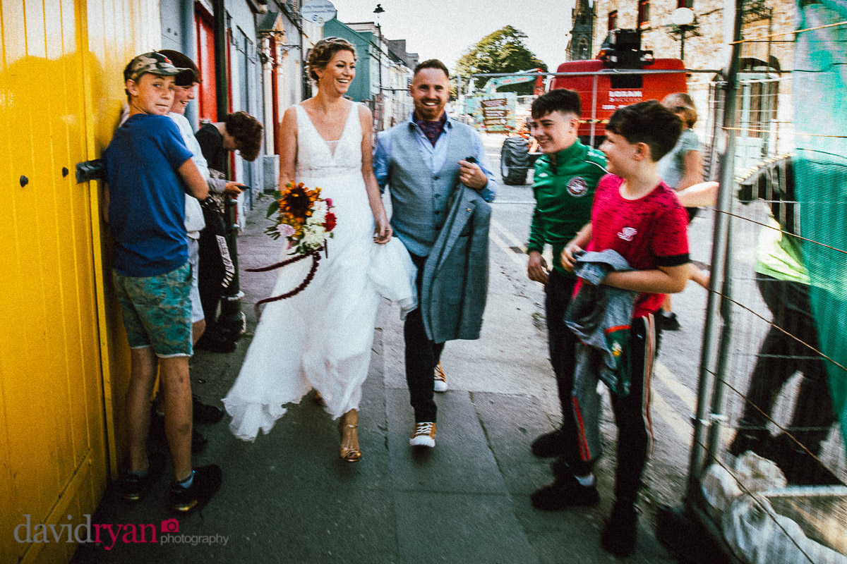 bride and groom walking down a street